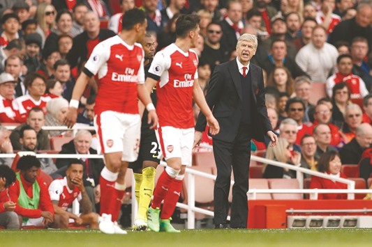 Arsenal manager Arsene Wenger (right) speaks to his players Francis Coquelin (left) and Mesut Ozil during the Premier League game against Manchester City at the Emirates Stadium in North London, yesterday. (Reuters)