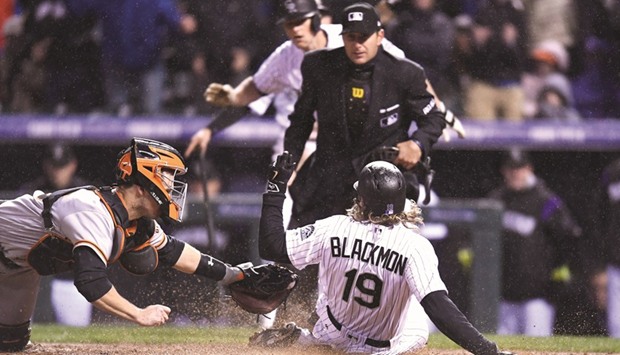 Colorado Rockies centre fielder Charlie Blackmon scores on a two run inside the park home run as San Francisco Giants catcher Buster Posey (L) attempts a tag in the fourth inning against the San Francisco Giants at Coors Field. PICTURE: USA TODAY Sports