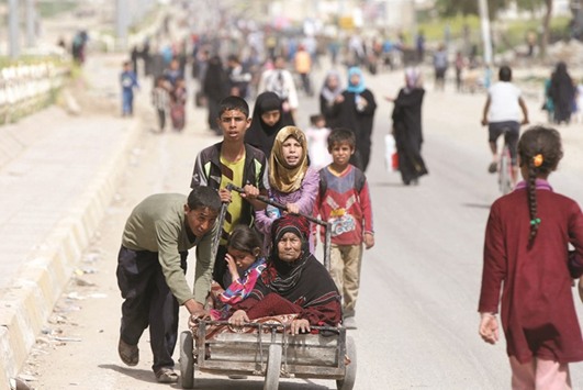 Displaced Iraqis push a wheelbarrow carrying a woman as they flee after a battle between the Iraqi Counter Terrorism Service and Islamic State militants in western Mosul yesterday.