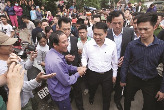 Hanoiu2019s Mayor Nguyen Duc Chung is greeted by villagers at the Dong Tam commune.