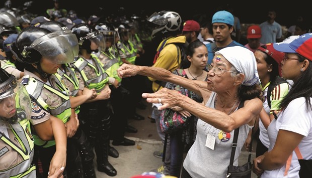 A woman confronts riot police during the rally in Caracas to honour victims of violence during protests against President Madurou2019s government.