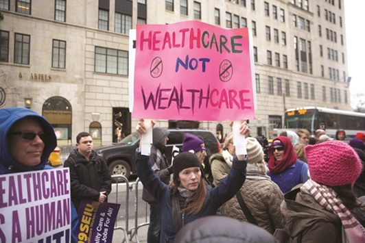 Healthcare activists lift signage promoting the Affordable Care Act during a rally as part of the national u201cMarch for Healthu201d movement in front of Trump Tower in New York City.