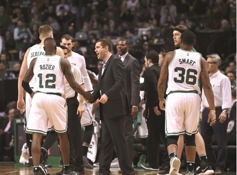 File picture of Boston Celtics head coach Brad Stevens (C) congratulating Boston Celtics guard Terry Rozier (L).