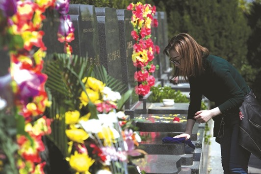 A woman cleans the grave of a relative ahead of the annual Qingming festival, or Tomb Sweeping Day, at a cemetery in Beijing. During Qingming, Chinese traditionally tend the graves of their departed loved ones to honour them.