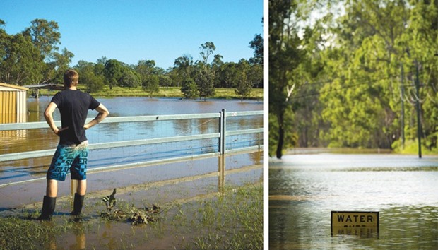 Resident Daniel Jones watches as floodwaters caused by Cyclone Debbie recede in the town of Beenleigh.  RIGHT: A road sign is seen partially submerged in floodwaters in North MacLean, Brisbane. Flooded rivers were still rising in two Australian states with two women dead and four people missing after torrential rains in the wake of a powerful tropical cyclone.