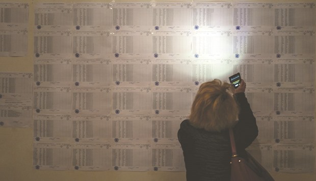 A woman uses her cellphone to read the votersu2019 list at a polling  station in Yerevan.