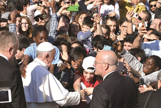 Pope Francis greets children on his arrival yesterday at the Basilica of St Bartholomew on Tiber Island, Rome.