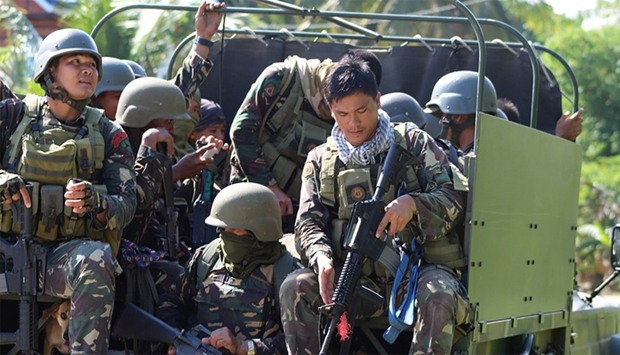 Philippine soldiers ride in the back of a military truck