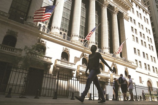 People walk by the New York Stock Exchange. Prices for protection against wild swings in stocks, bonds and the euro surged last week as polls have tightened and  investors fretted that another unforseen election outcome could upend a solid start to the year for risk assets.