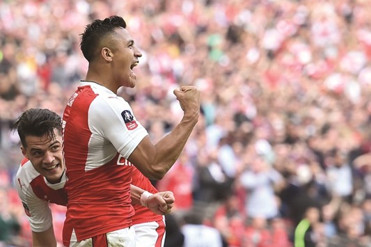 Arsenalu2019s Chilean striker Alexis Sanchez (R) celebrates after scoring the second goal during the FA Cup semi-final match against Manchester City at Wembley stadium.