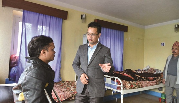Samrat Basnet, right, gestures as he speaks with an earthquake survivor at his clinic in Kathmandu.