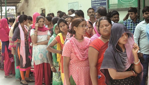 People queue up at a polling booth to cast their votes in New Delhi yesterday.
