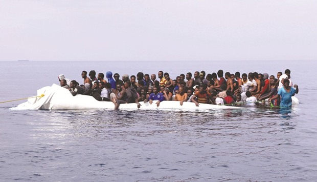 This file photo taken on March 20 shows migrants waiting to be rescued from a sinking dinghy off the Libyan coastal town of Zawiyah, as they attempted to cross from the Mediterranean to Europe. An Italian prosecutor has claimed that charity boats rescuing migrants in the Mediterranean are in direct contact with people traffickers in Libya, tantamount to providing a u2018taxiu2019 service to Europe.