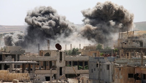 Smoke billows from buildings in a rebel-held neighbourhood of Daraa following reported air strikes yesterday.