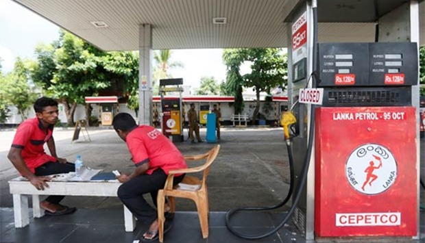 Workers rest at a fuel station in Colombo on Monday.