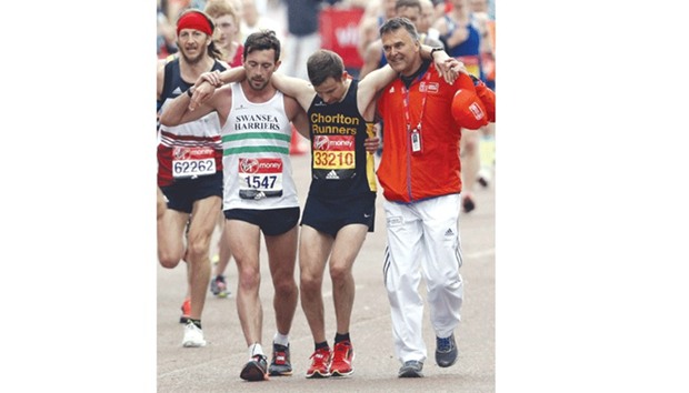 Matthew Rees (left) helps David Wyeth complete the London Marathon.