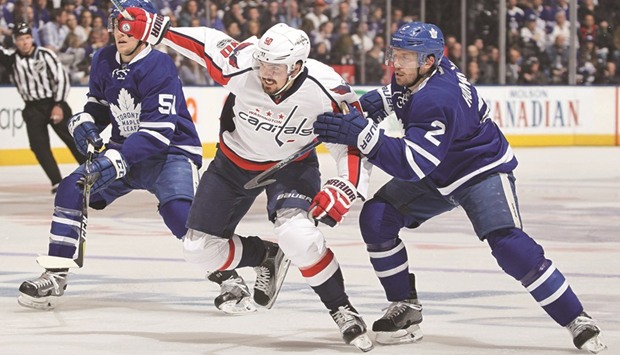 Marcus Johansson (centre) of the Washington Capitals skates between Jake Gardiner (left) and Matt Hunwick of the Toronto Maple Leafs in Game Six of the Eastern Conference quarter-finals during the 2017 NHL Stanley Cup Playoffs in Toronto, Canada, on Sunday. (AFP)