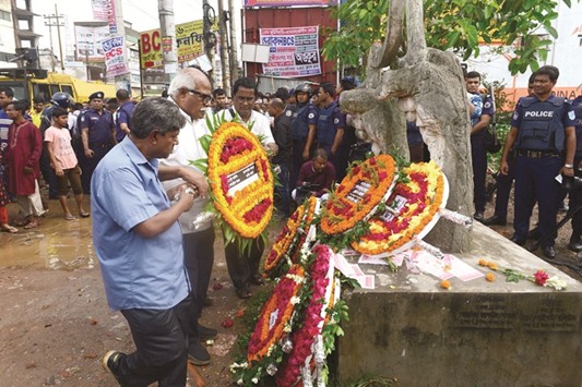 Activists place a wreath at a monument as they mark the fourth anniversary of the Rana Plaza building collapse at the site where the building once stood in Savar, on the outskirts of Dhaka, yesterday.