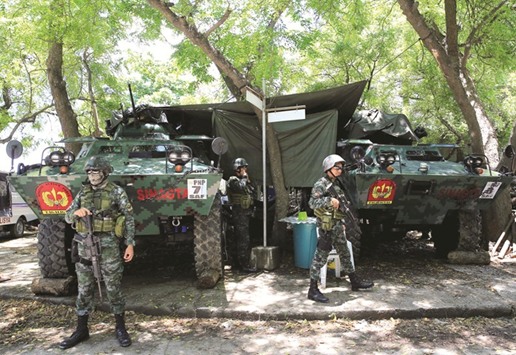 Members of the Philippine National Police Special Action Force (PNP-SAF) stand guard in front of armoured vehicles stationed near the venue of the upcoming Association of South East Asian Nation (Asean) summit as they provide security for guests and VIPs at the convention centre in Pasay City, Metro Manila, yesterday.