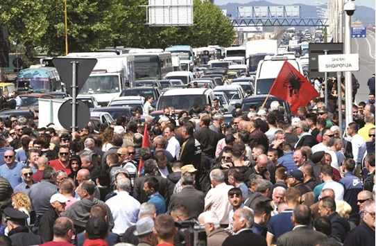 Supporters of the Albanian opposition stand in the middle of a main artery of the capital Tirana, blocking traffic for one hour, during their protest yesterday.