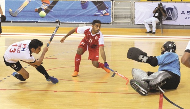 Qataru2019s Sheraz Ali (left) in action against Oman during their Pool u2018Au2019 match of the Indoor Asia Cup at Aspire Zone yesterday.