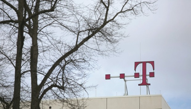 The T-Mobile logo is seen on top of the Deutsche Telekom headquarters in Bonn, Germany. The European Commission is proposing a minimum spectrum licence duration of 25 years in a telecoms reform proposal for member states in September.