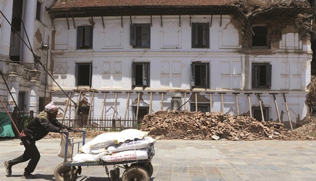 A porter pushes a cart through Basantapur Durbar Square, a Unesco World Heritage site damaged during the 2015 earthquake, in Kathmandu yesterday.