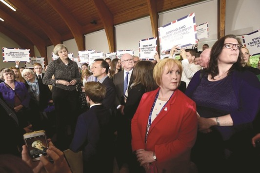 Prime Minister Theresa May stands with supporters at the Brackla community centre in Bridgend, south Wales, yesterday.