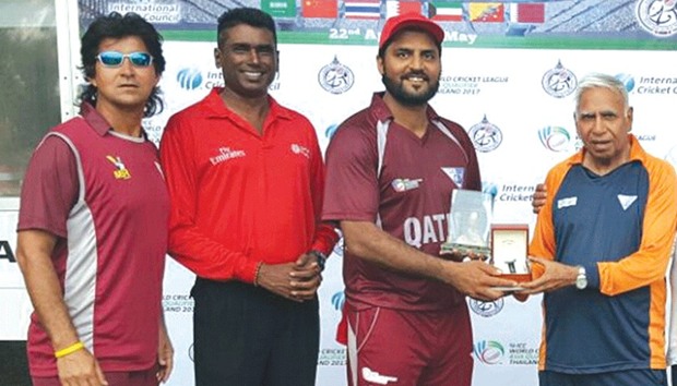 Awais Malik receives his man of the match trophy from Qatar cricket operations manager Manzoor Ahmed.