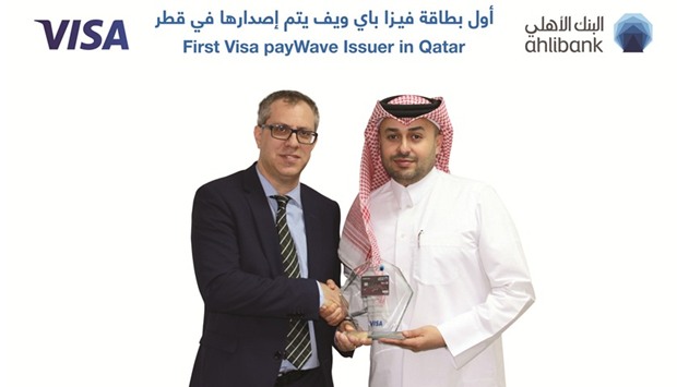 An Ahlibank executive receives award from a Visa International official.