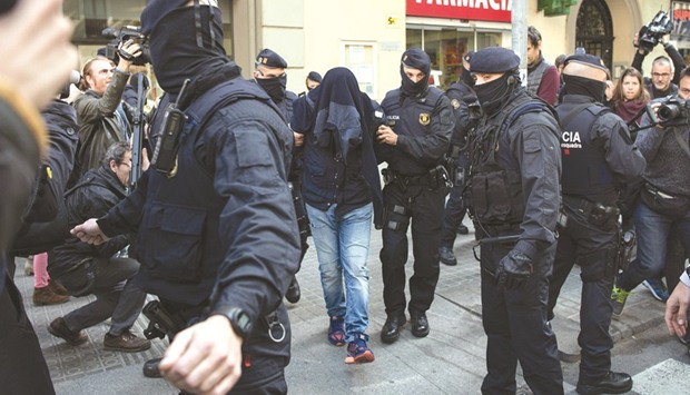 Members of the Catalan Regional Police (Mossos du2019Esquadra) arrest a man accused of collaborating with the Islamist militants, after searching a flat in Barcelona yesterday.