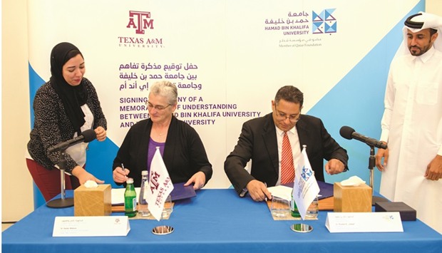 Dr Letaief and Dr Watson signing the agreement.