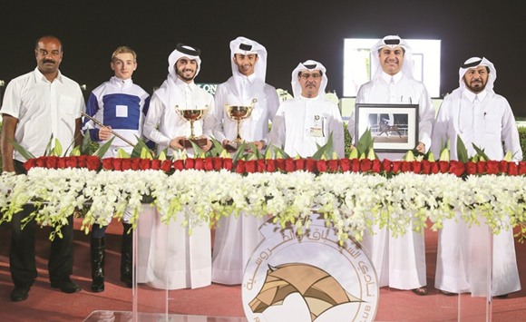 Qatar Racing and Equestrian Club (QREC) vice chief steward Abdulla Rashid a-Kubaisi with the winners of the Fuweiret Cup after Caid De Lu2019Ardus won the six furlong race at the QREC yesterday. PICTURE: Juhaim