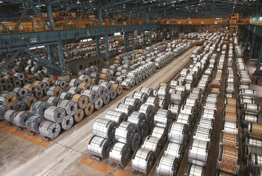 Rolls of steel are stacked inside a plant in Shanghai. Chinau2019s industrial firms have been enjoying their best profits in years in recent months as a construction boom and government-mandated cuts in excess capacity led to sharp increases in prices of raw materials such as iron ore and coal.