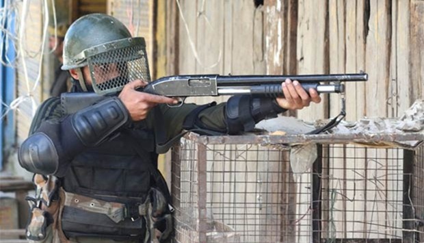 An Indian soldier aims a pellet gun towards Kashmiri protesters during a clash in the Panzgam village of Kupwara, north of Srinagar, on Thursday.