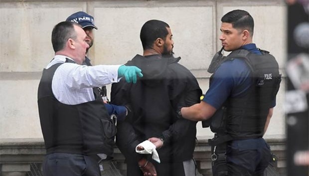 A man is held by police in Westminster in London on Thursday.