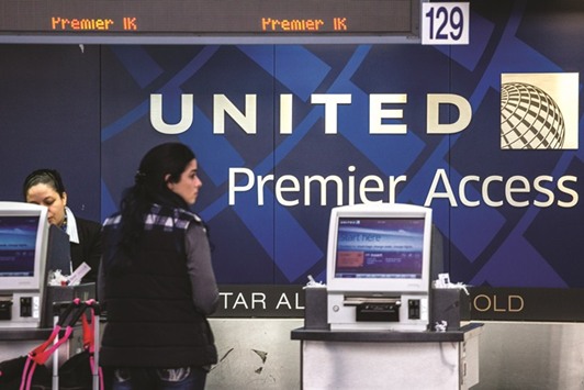 An employee assists a passenger inside the United Continental Holdings terminal at Newark Liberty International Airport (EWR) in Newark, New Jersey. Rigid policies for handling cases where passengers must be denied boarding u201cgot in the way of our values,u201d United chief executive officer Oscar Munoz said in the statement.
