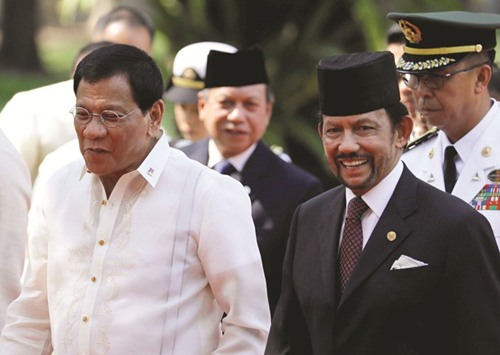 Brunei Sultan Hassanal Bolkiah smiles as he walks with President Rodrigo Duterte at the presidential palace yesterday ahead of the Association of Southeast Asian Nations summit in Manila.