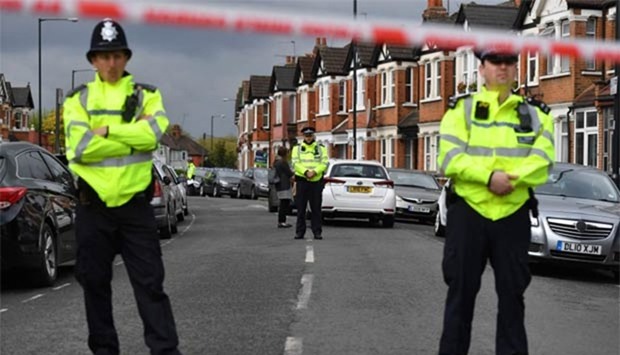 British police officers secure a cordon in a residential street in north-west London on Friday where firearms officers shot a woman.