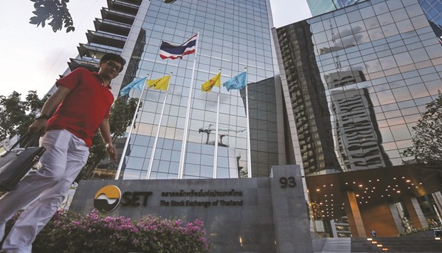A pedestrian walks past the Stock Exchange of Thailand building in Bangkok. Thai stocks, the second-worst performers among Asian emerging markets in 2017, face more headwinds as an unexpected jump in bad loans at banks weighs on investor sentiment.