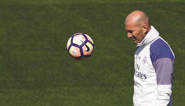 Real Madridu2019s French coach Zinedine Zidane plays with the ball during a training session at Valdebebas Sport City in Madrid yesterday.
