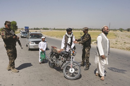 Security personnel search travellers at a checkpoint on the outskirts of Jalalabad yesterday.
