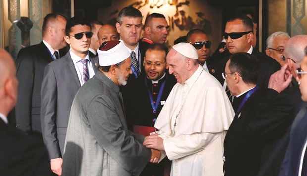 A handout picture released by Egyptu2019s Al-Azhar Media Centre shows Pope Francis shaking hands with Sheikh Ahmed al-Tayeb, the Grand Imam of Al-Azhar, during a visit to the prestigious institution in Cairo yesterday.