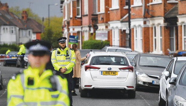 Police officers secure a cordon in a residential street in north-west London yesterday where firearms officers shot a female subject after they carried out a specialist entry into an address as part of a counter terrorism investigation.