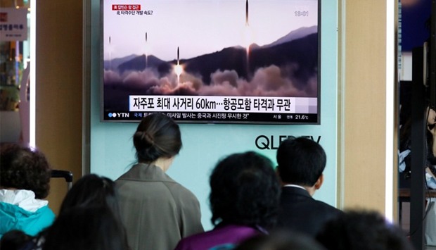 People watch a TV broadcasting a news report on North Korea's missile launch