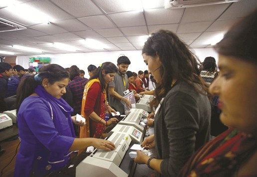 Workers laminate votersu2019 identity cards as they prepare for the upcoming local election of municipalities and villages representatives at the election commission in Kathmandu.