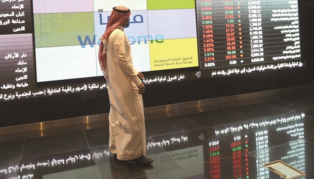 A Saudi investor monitors share prices at the Saudi Stock Exchange, or Tadawul (file). Saudi Arabia aims to start listing foreign companies on its stock market as soon as this year as it seeks to become a regional centre for equity issuance.