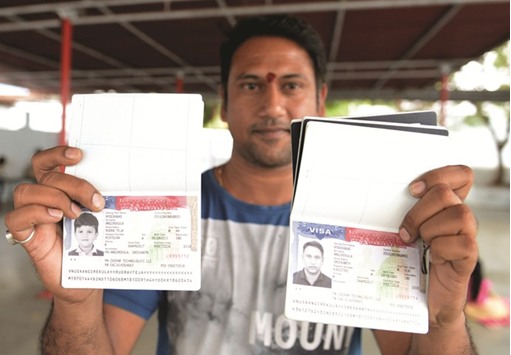 Angirekula Sreekanth poses for a photograph with a copy of his US visa and those of his relatives at the Chilkur Balaji Temple in Rangareddy district, some 30km from Hyderabad, yesterday.