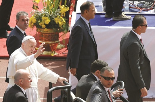Personal security surrounds Pope Francis as he arrives to hold a mass in Cairo, Egypt, yesterday.