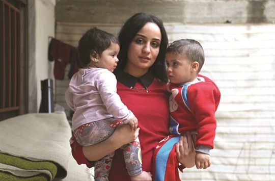Twenty-three-year-old Islam Maytat from Morocco poses for a photo with her children Maria (left) and Abdullah in the Kurdish-majority city of Qamishli in northern Syria.